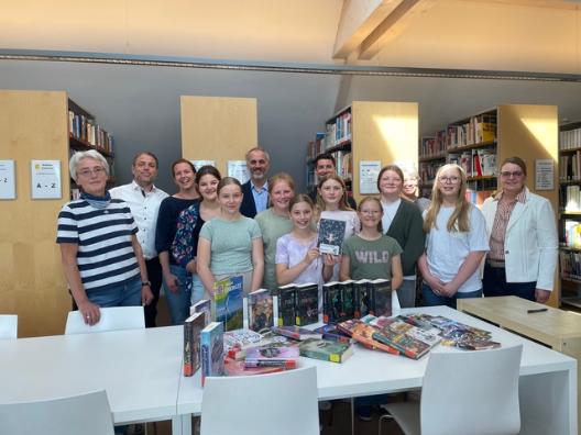 Die Schülerinnen der R6b, die beim letzten Bücherflohmarkt mitgearbeitet haben, freuen sich besonders über die vielen neuen Bücher.